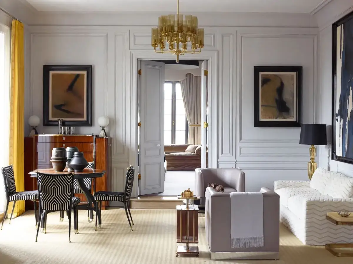 Elegancki salon z nowoczesnym malarstwem, meblami w stylu art déco i złotym żyrandolem.