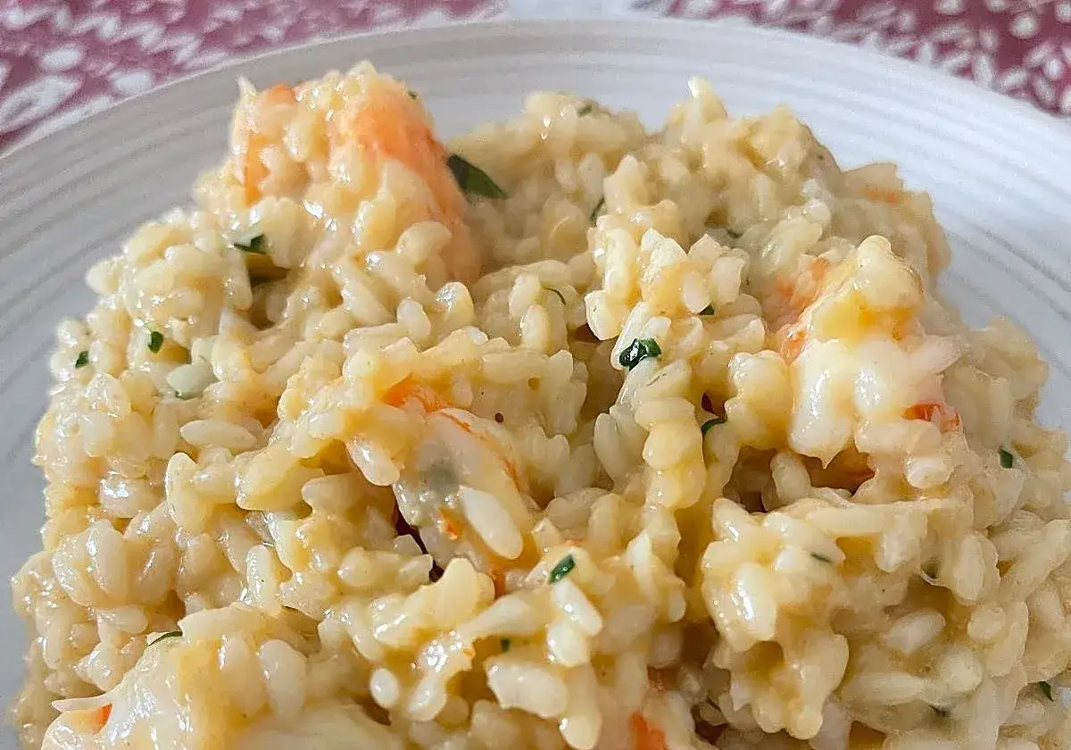 Cremoso risotto de langostinos, con trozos rosados de marisco y un toque de perejil picado.
