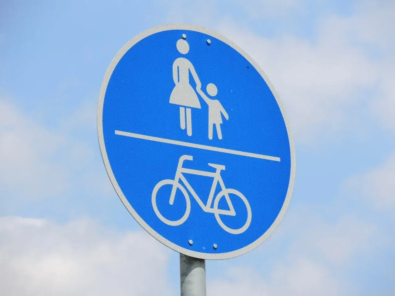Blaues Schild zeigt oben eine Frau mit Kind, unten ein Fahrrad. Es erkl&auml;rt, was ist ein Gehweg: ein Weg f&uuml;r Fu&szlig;g&auml;nger und Radfahrer.