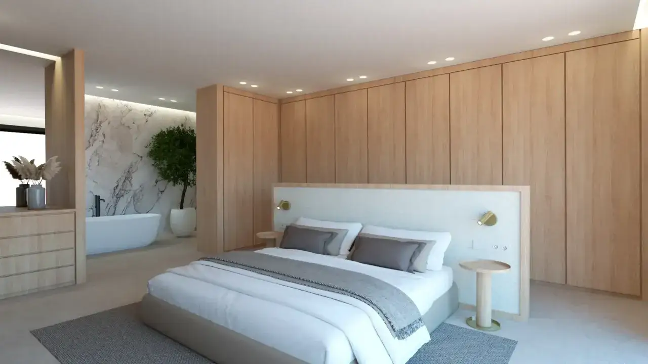 Dormitorio moderno con cama king size, armarios de madera y un ba&ntilde;o suite con ba&ntilde;era exenta y pared de m&aacute;rmol.