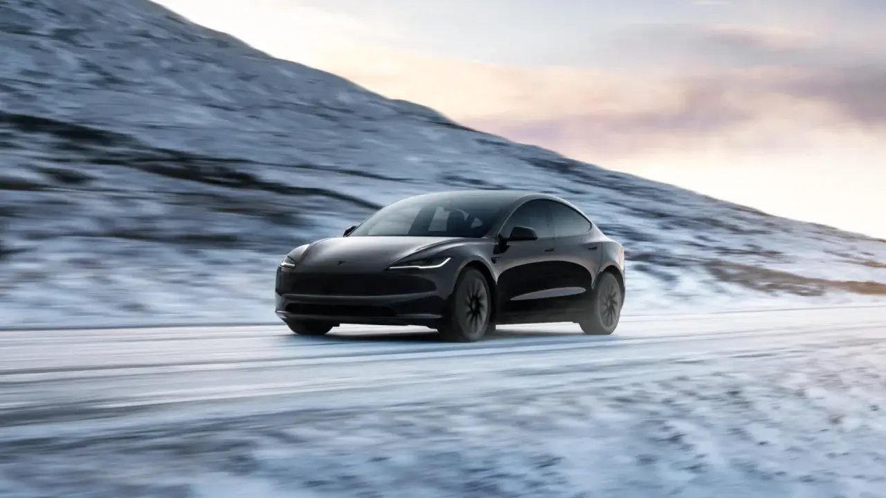 Czarny Tesla jedzie po zaśnieżonej drodze. To właśnie tesla, co to za samoch&oacute;d?