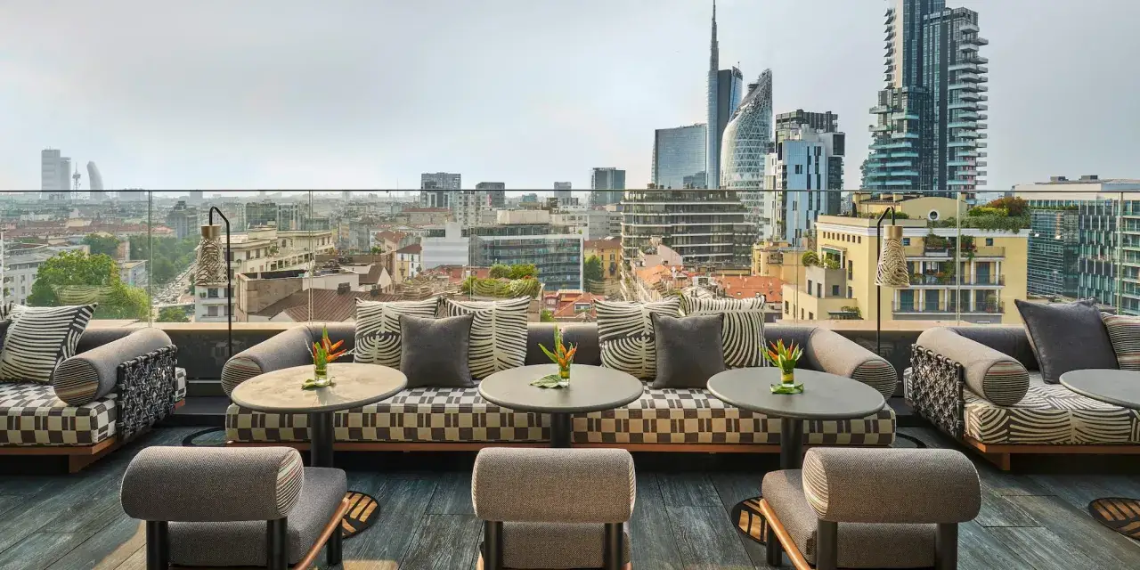 Terrazza panoramica con arredi eleganti, ideale per godersi un aperitivo nei locali chic di Milano.