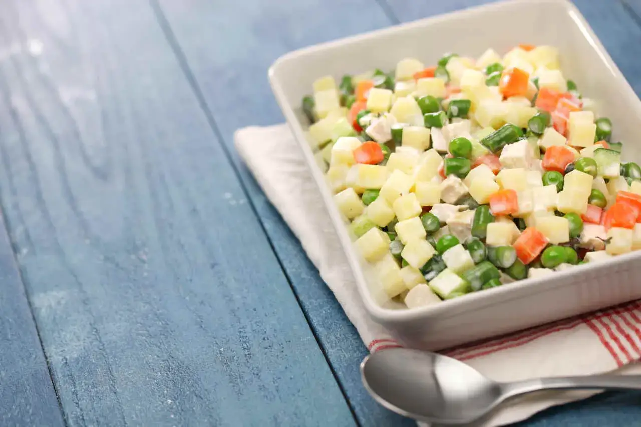 Insalata di patate lesse con piselli, carote e pollo. Un'idea fresca e gustosa per un pasto leggero.