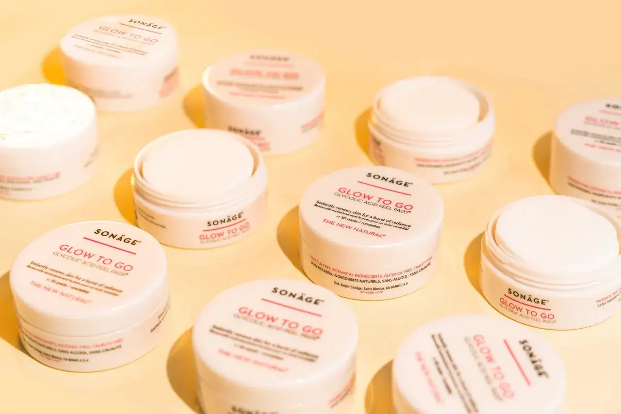 Flera burkar med Sonäge Glow to Go Glykolsyra Peel Pads, en del av hudvård för en strålande hud.