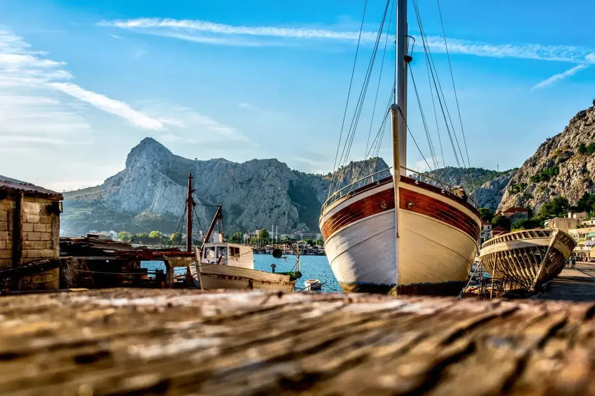 Widok na port w Chorwacji, z górami w tle. Zastanawiasz się, co zabrać na wyjazd do Chorwacji?