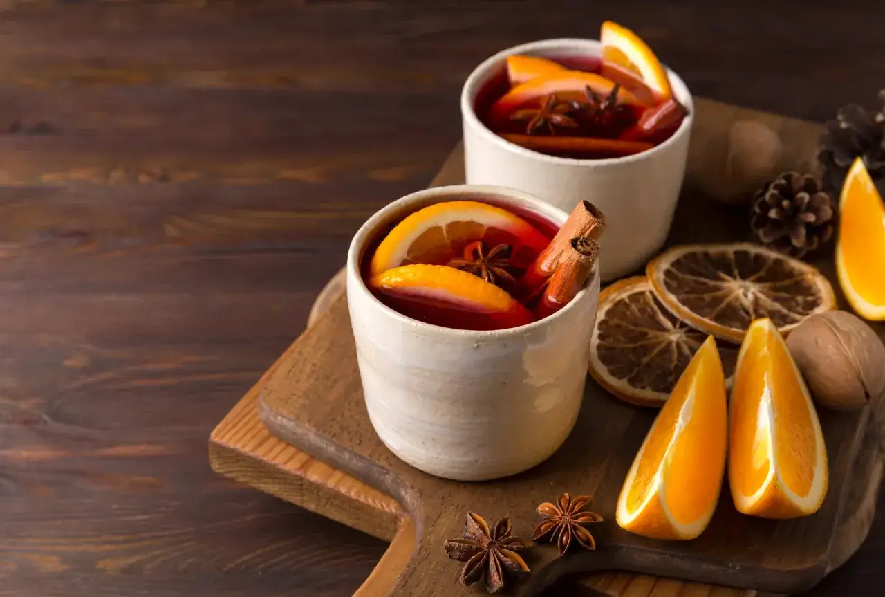 Deux tasses de boisson chaude aux épices, oranges et cannelle. Parfait pour une recette vin chaud sans alcool.