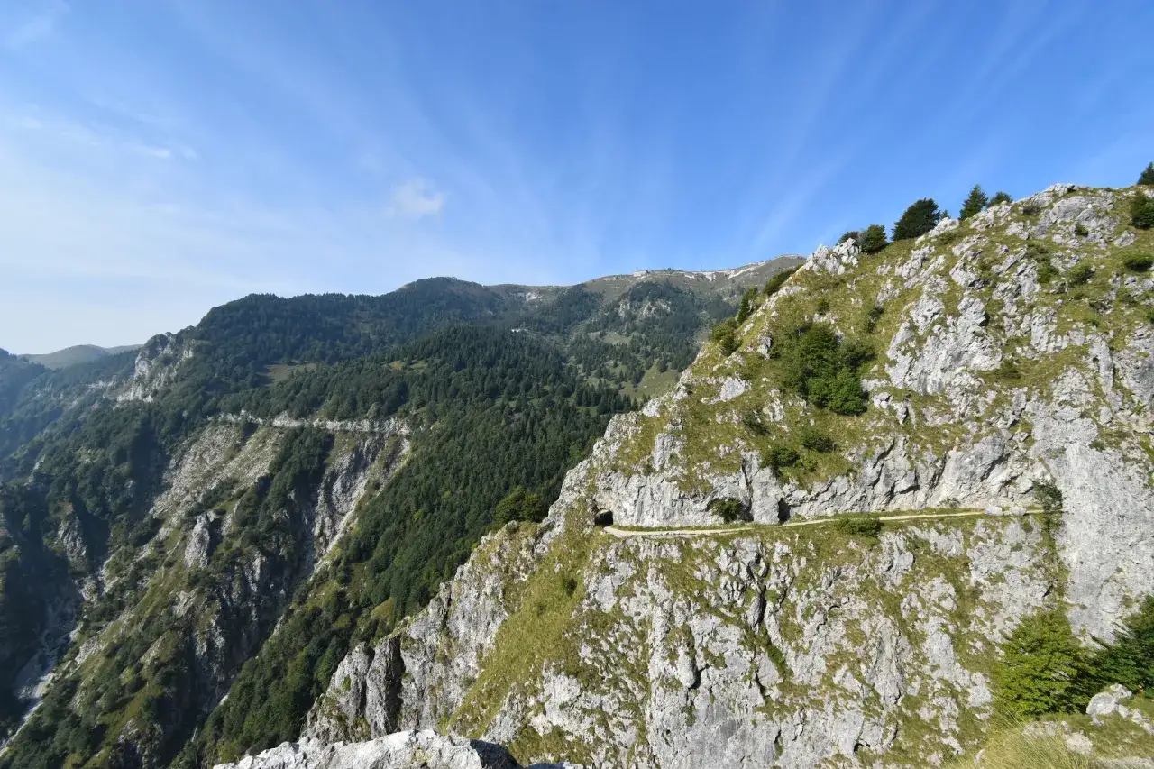 Sentieri facili sul Monte Grappa, con un percorso che serpeggia tra rocce e vegetazione, offrendo panorami mozzafiato.