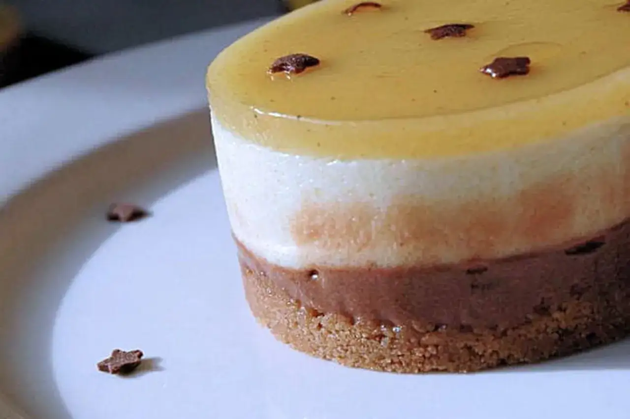 Un délicieux bavarois poire aux trois couches, garni de petites étoiles en chocolat sur un lit de biscuit croustillant.