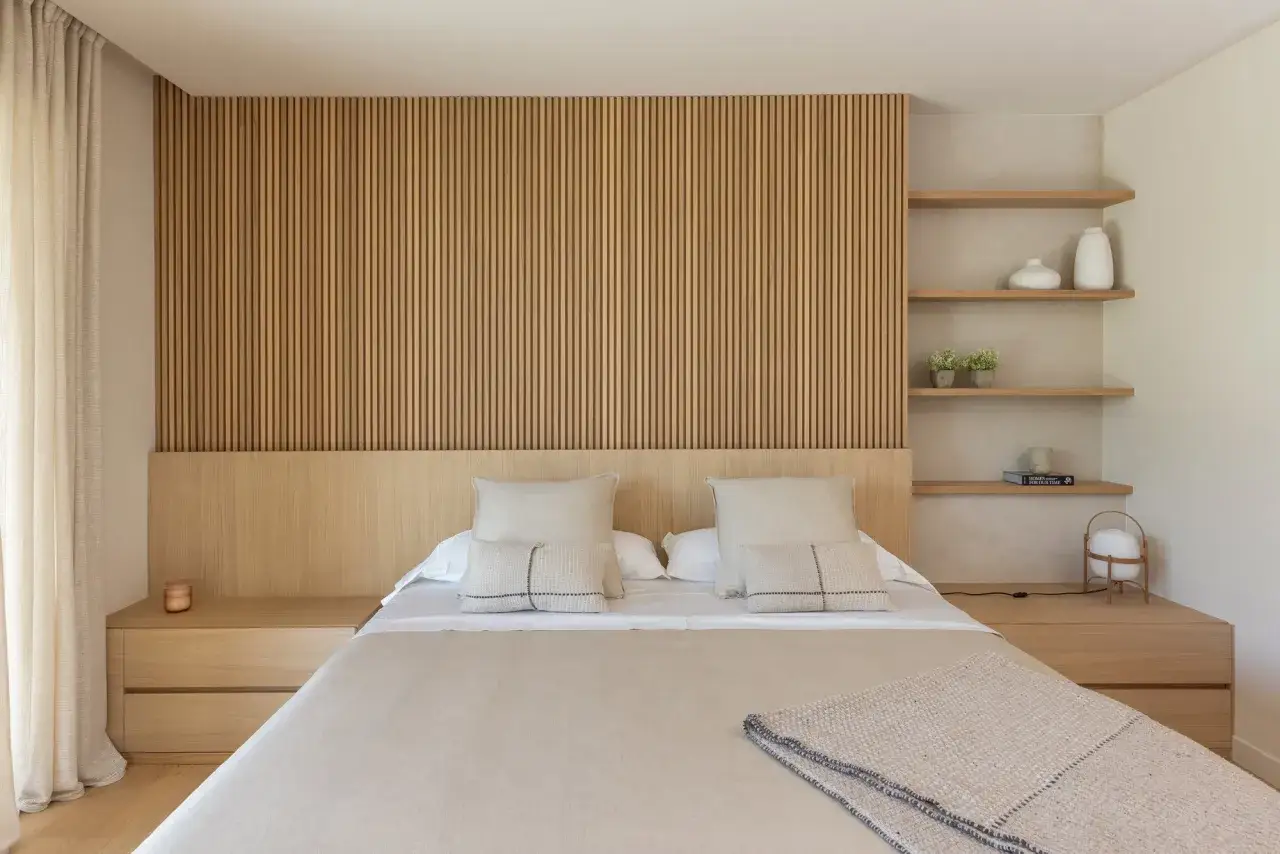 Ideas para decorar la pared de la cabecera de la cama con lamas de madera y estantes flotantes.