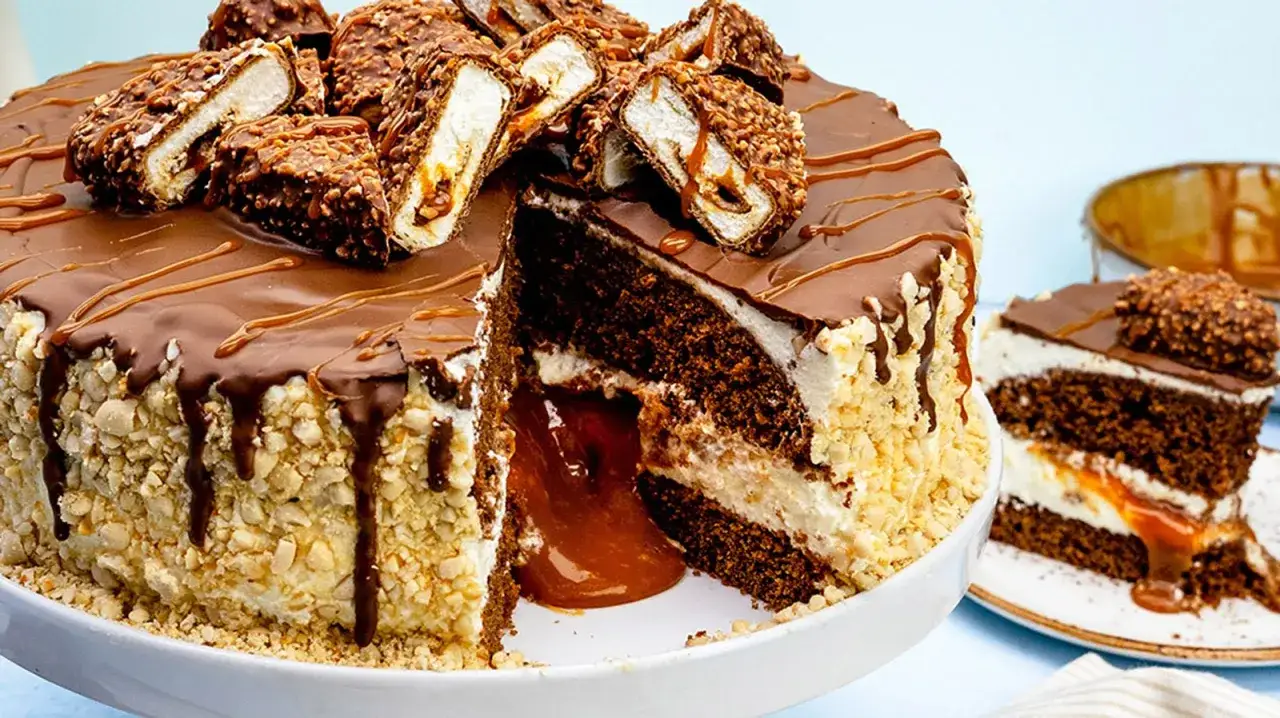 Ein saftiger maxi king kuchen mit Schokoladenglasur, Karamellfüllung und Nüssen. Ein Stück davon ist auf einem Teller angerichtet.