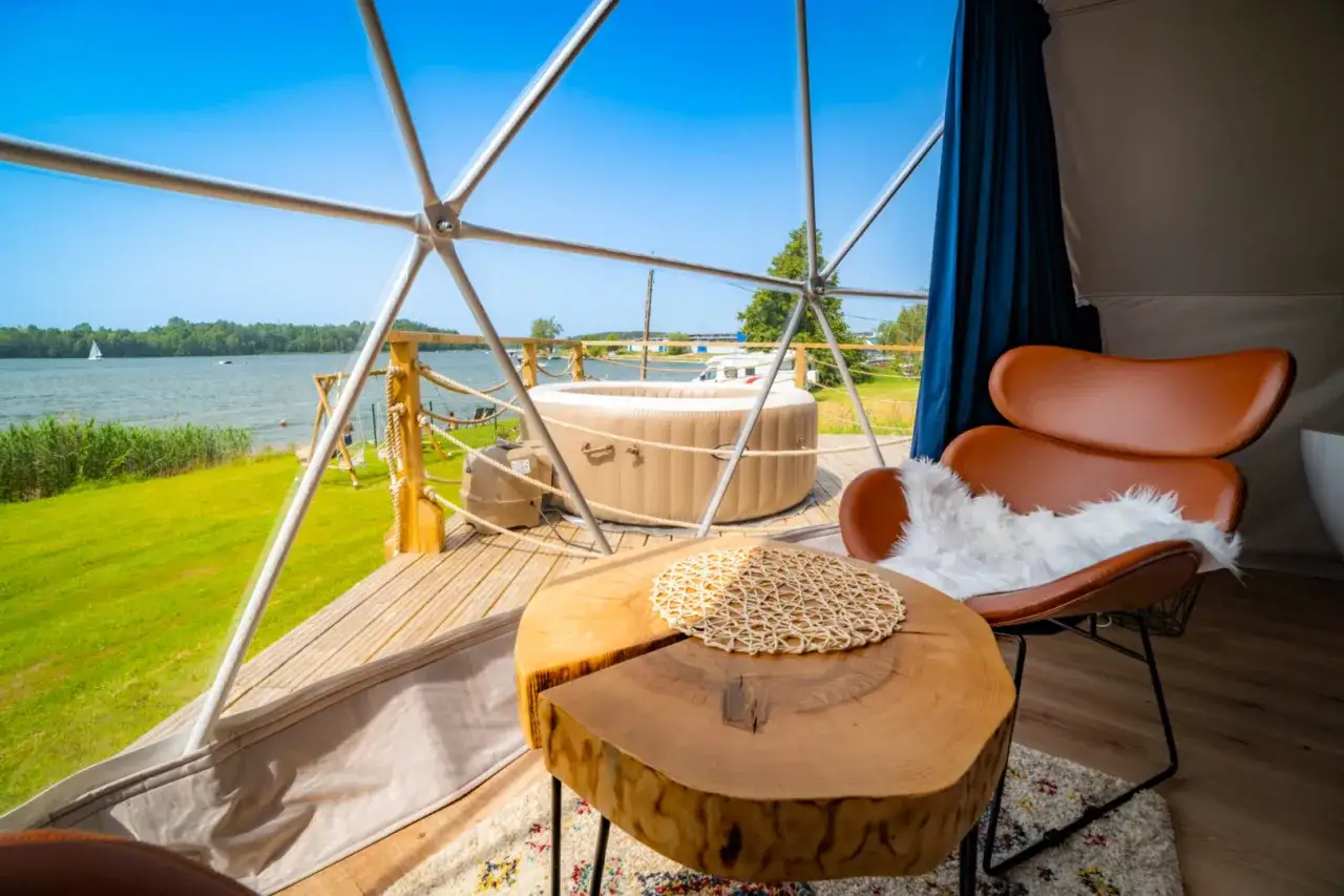Idealny pomysł na wyjazd urodzinowy: domek z widokiem na jezioro, jacuzzi i wygodny fotel.