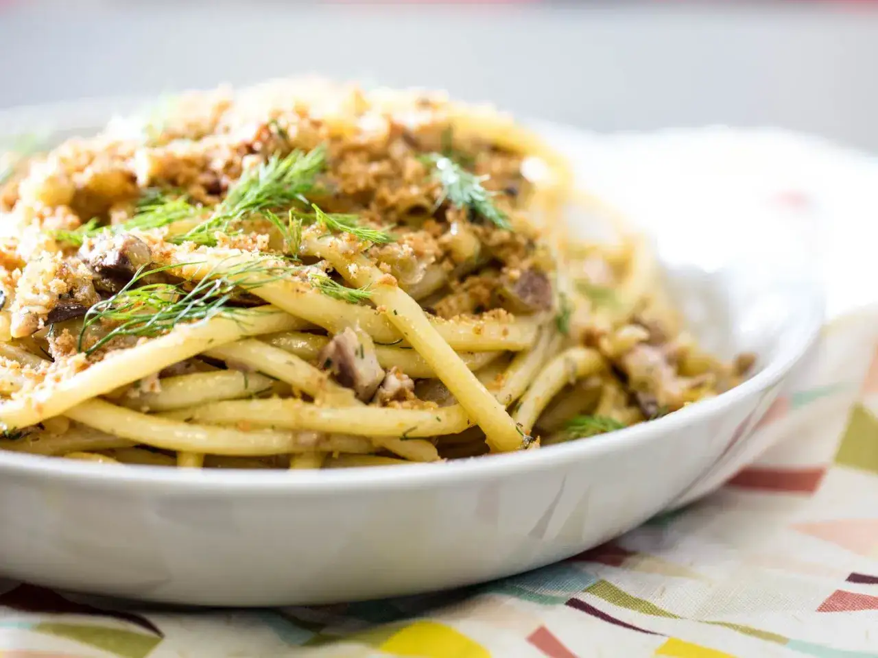Un plat de pâtes généreux, garni de miettes croustillantes et d'aneth frais. Un délice de pasta con le sarde.