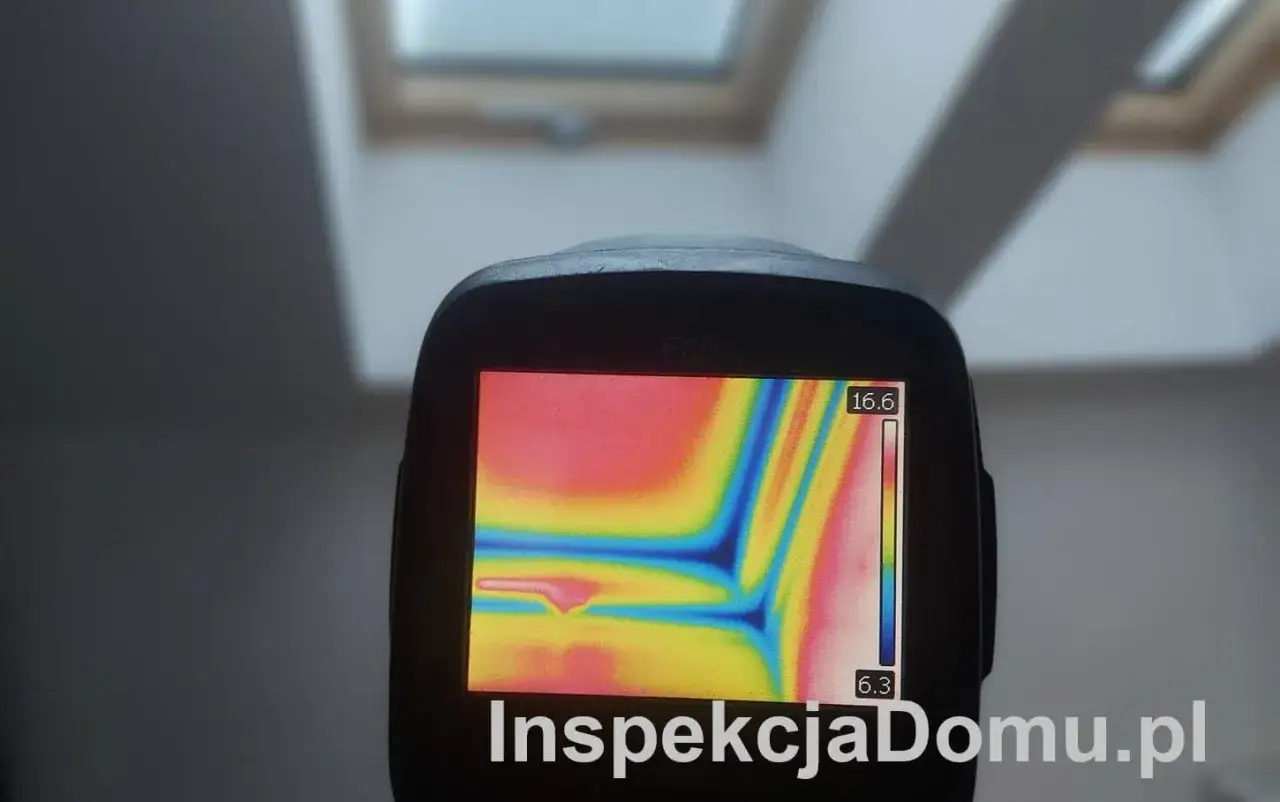 Badanie kamerą termowizyjną ujawnia mostki termiczne na poddaszu. Kolory na ekranie pokazują różnice temperatur.