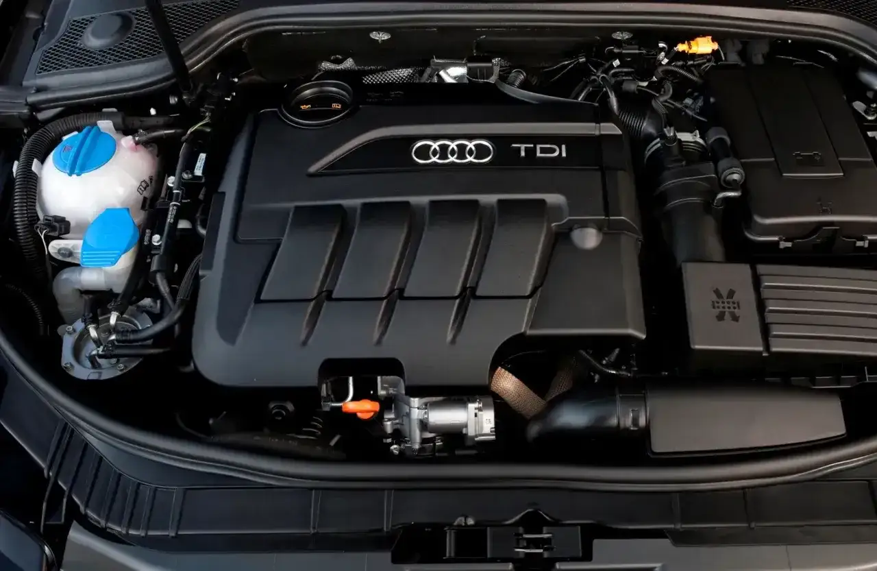 Silnik TDI w Audi A3. Widoczny jest czarny plastikowy kolektor z logo Audi i napisem TDI.