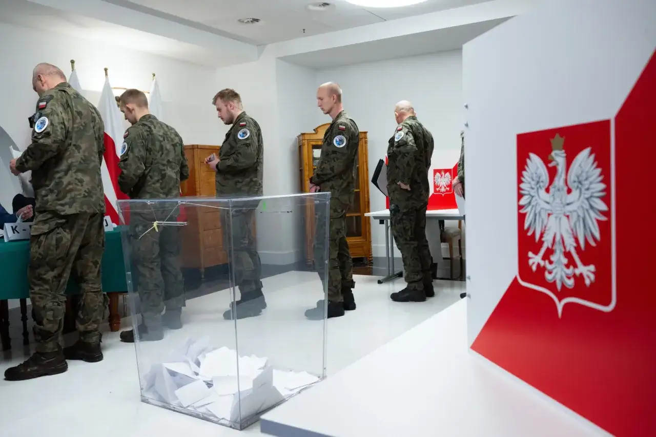 Żołnierze w mundurach głosują za granicą. Widać urnę wyborczą i polskie flagi.