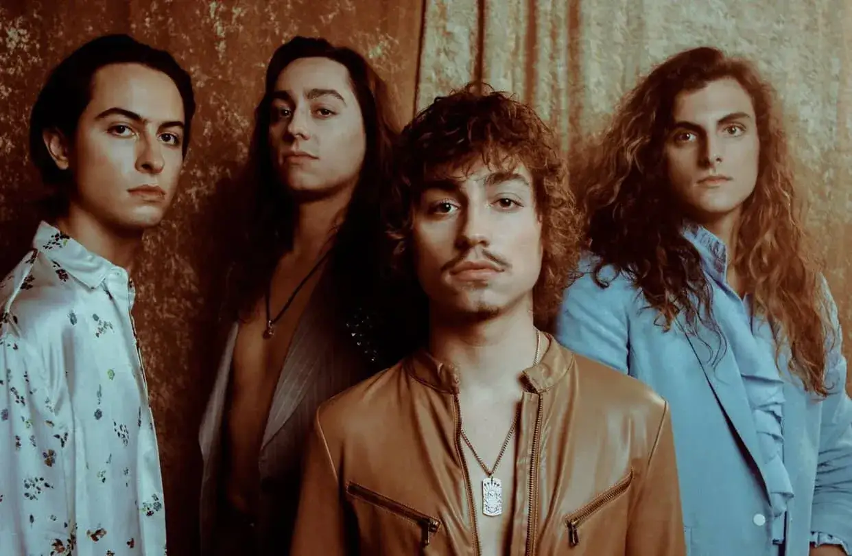 Członkowie Greta Van Fleet pozują do zdjęcia w stylowych strojach.