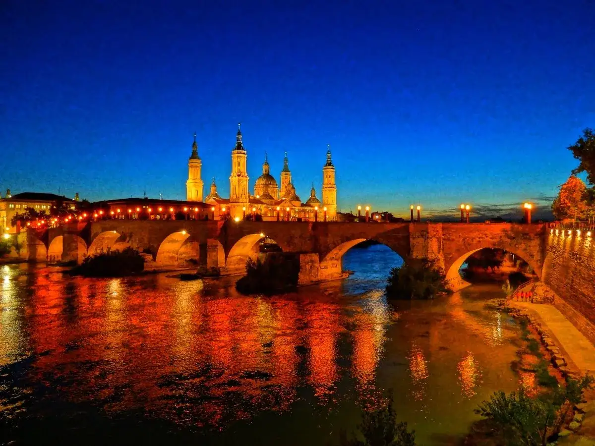 Puente de Piedra y Basílica del Pilar iluminados al anochecer, un imprescindible que ver en Zaragoza en 1 día.