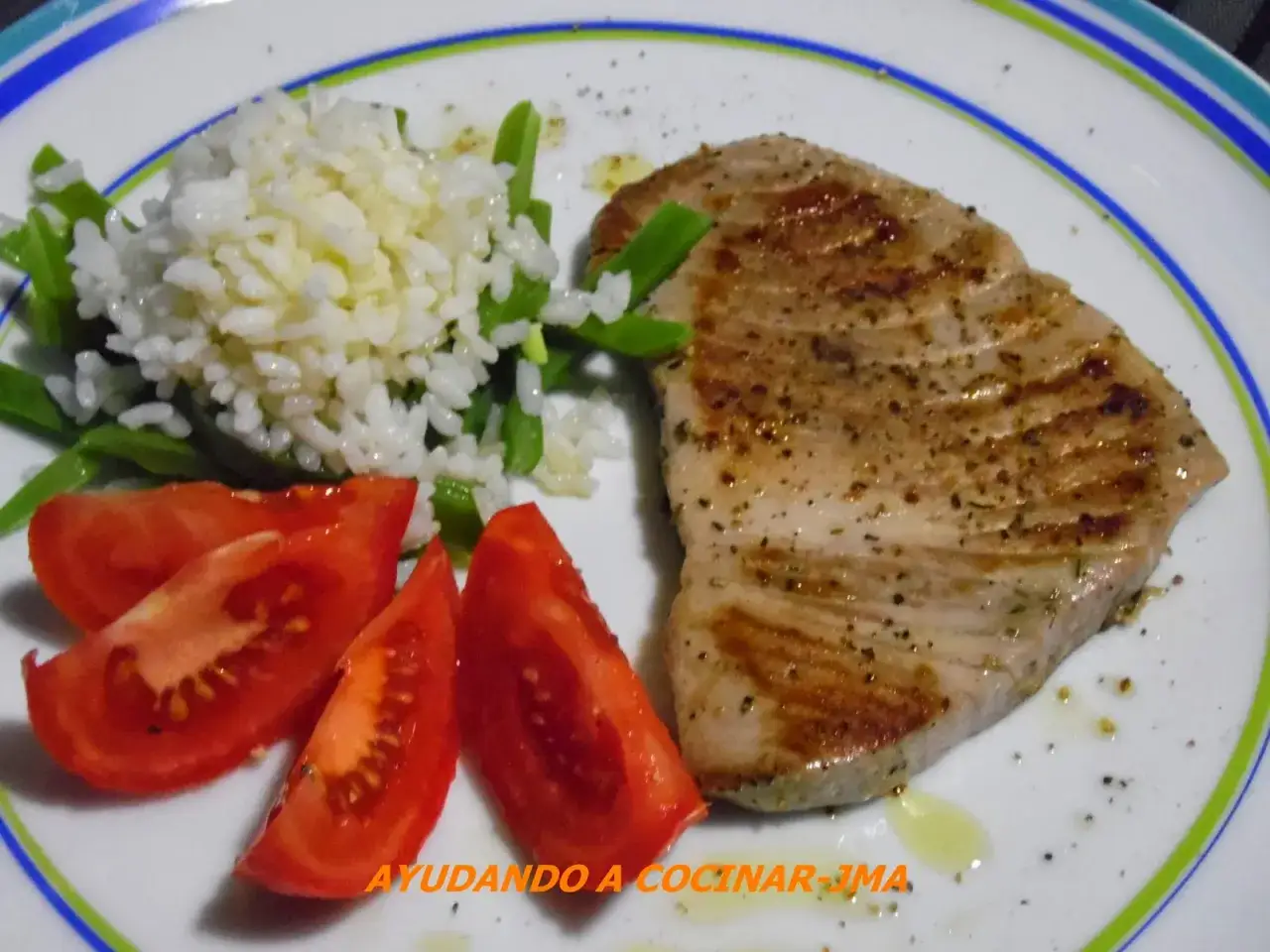 Un jugoso atún a la plancha, servido con arroz blanco, judías verdes y rodajas de tomate fresco. ¡Un plato saludable y delicioso!