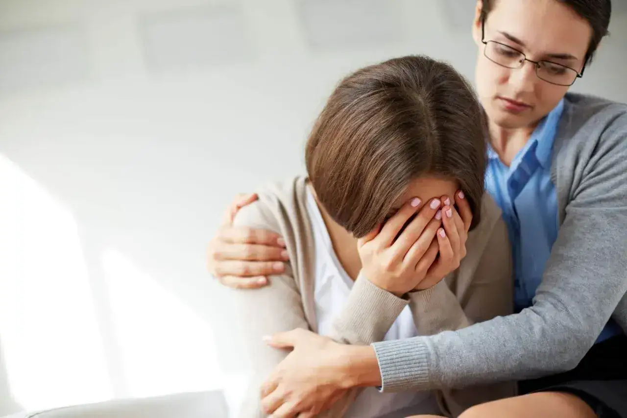 Kobieta pocieszana przez drugą. Rozmowa o stażu pracy zmarłego a renta rodzinna.