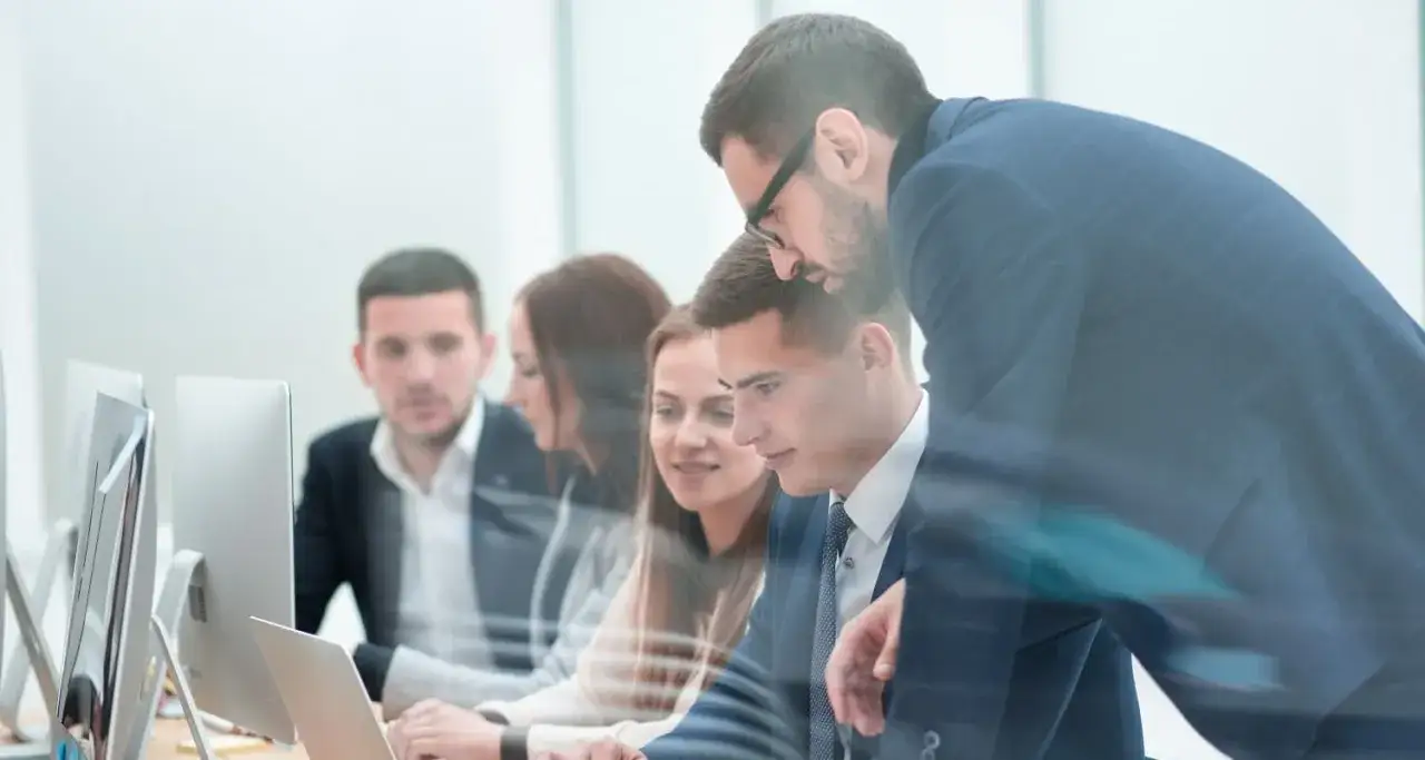 Equipo colaborando en la oficina, discutiendo modelos de gestión y estrategias de trabajo.