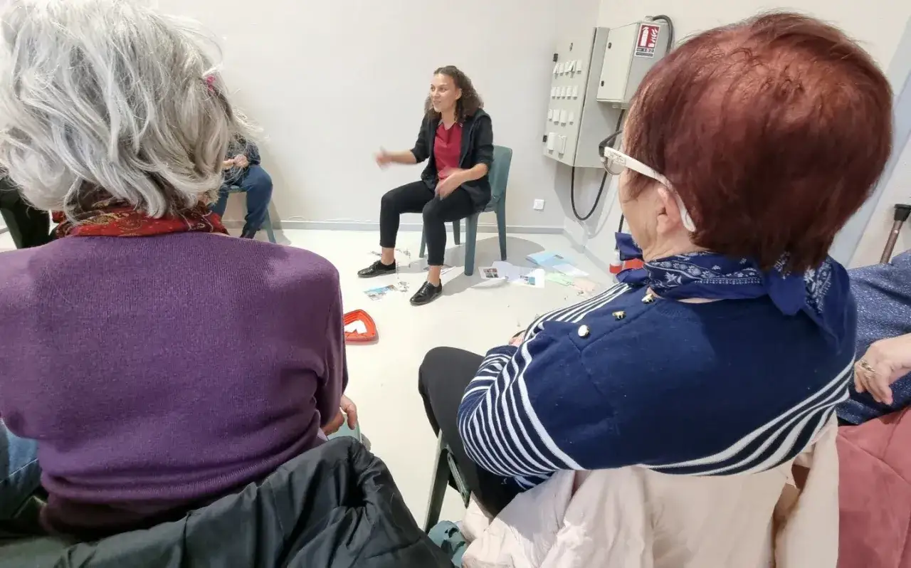 Des personnes participent &agrave; des activit&eacute;s pour pr&eacute;parer leur retraite. Une animatrice explique des choses.