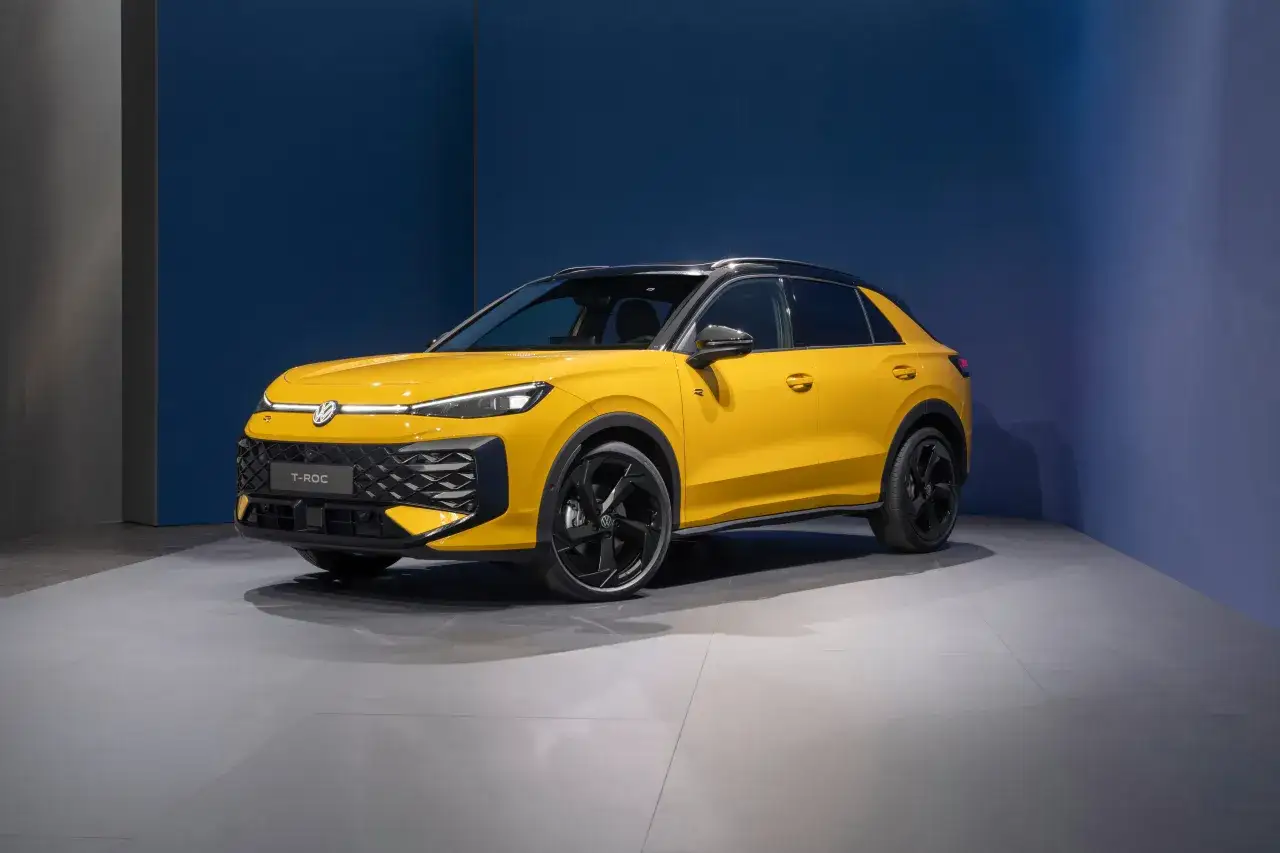 El nuevo Volkswagen T-Roc 2026, un SUV compacto amarillo vibrante, se exhibe con un diseño moderno y llantas negras deportivas.