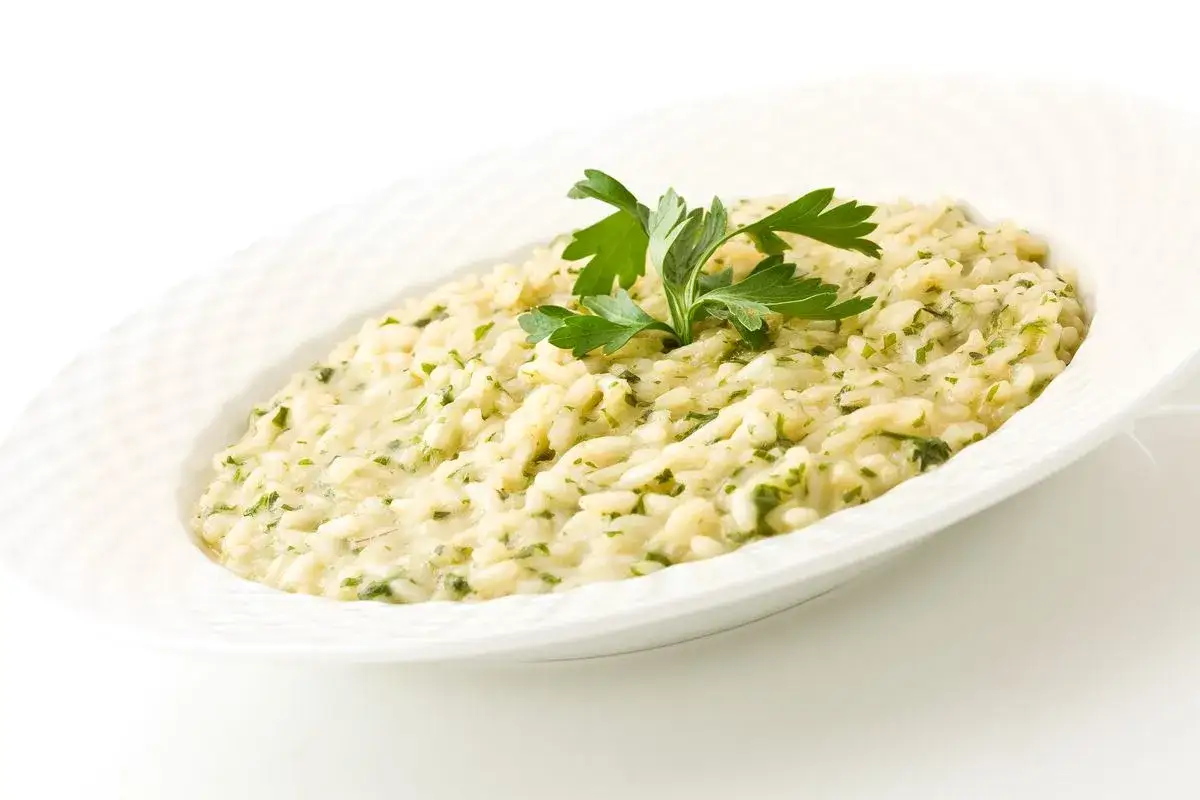 Un cremoso risotto di go Burano, arricchito da erbe fresche e guarnito con prezzemolo.