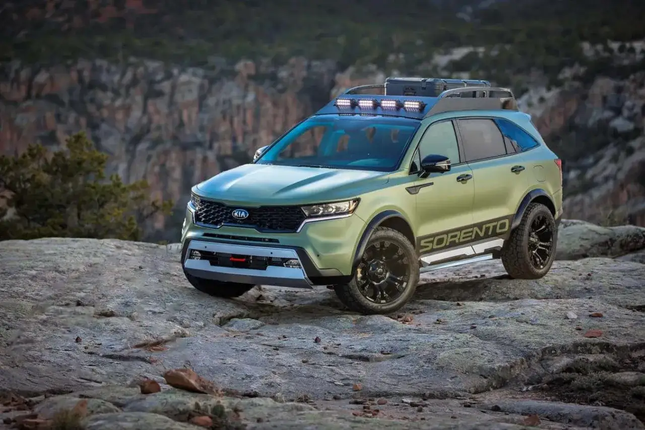 Kia Sorento preparado para aventura, con barras de luz en el techo y llantas todoterreno, posado en un paisaje rocoso.
