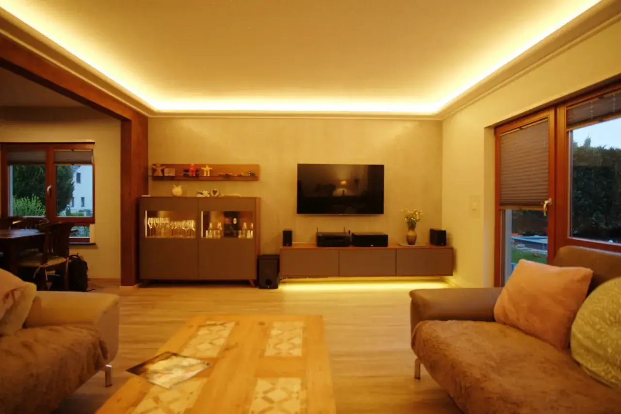 Gemütliches Wohnzimmer mit indirekter Beleuchtung an der Wand, die eine warme Atmosphäre schafft.