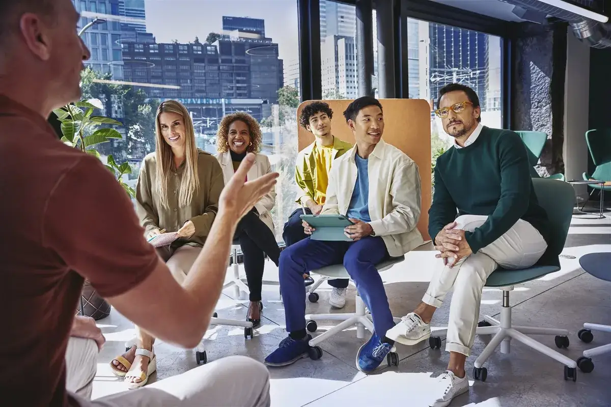 Gruppo eterogeneo discute in un ufficio moderno, un esempio di come le risorse umane promuovono la collaborazione e l'innovazione.