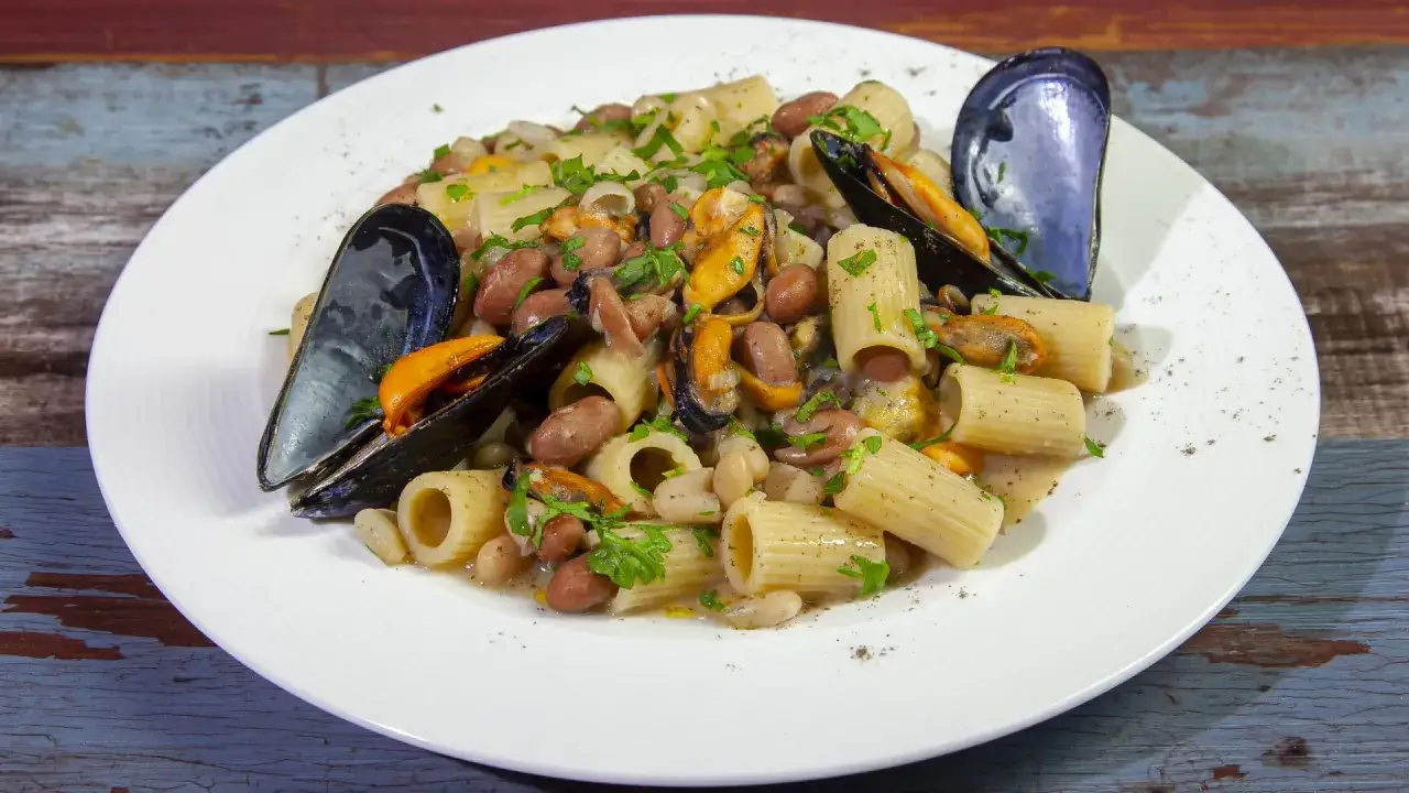 Piatto di pasta fagioli e cozze, un classico saporito, con rigatoni, fagioli borlotti e cannellini, cozze nere e prezzemolo fresco.