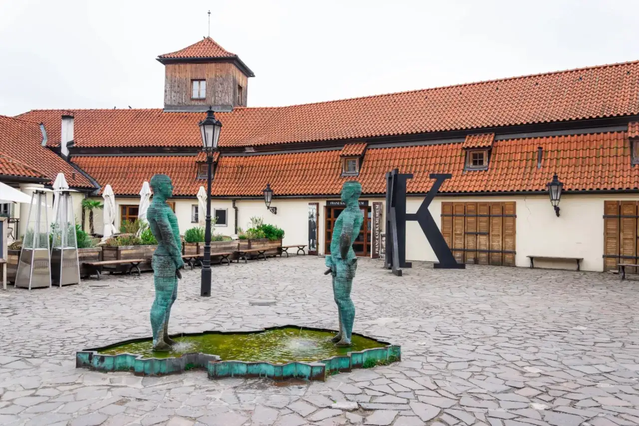 Dwie rzeźby sikających mężczyzn przed Muzeum Sztuki Współczesnej Praga.