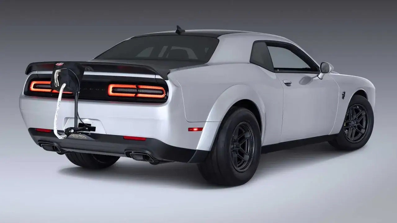 Srebrny Dodge Challenger Demon z czarnym dachem i spojlerem, z zamontowanym na tyle uchwytem na koło zapasowe.