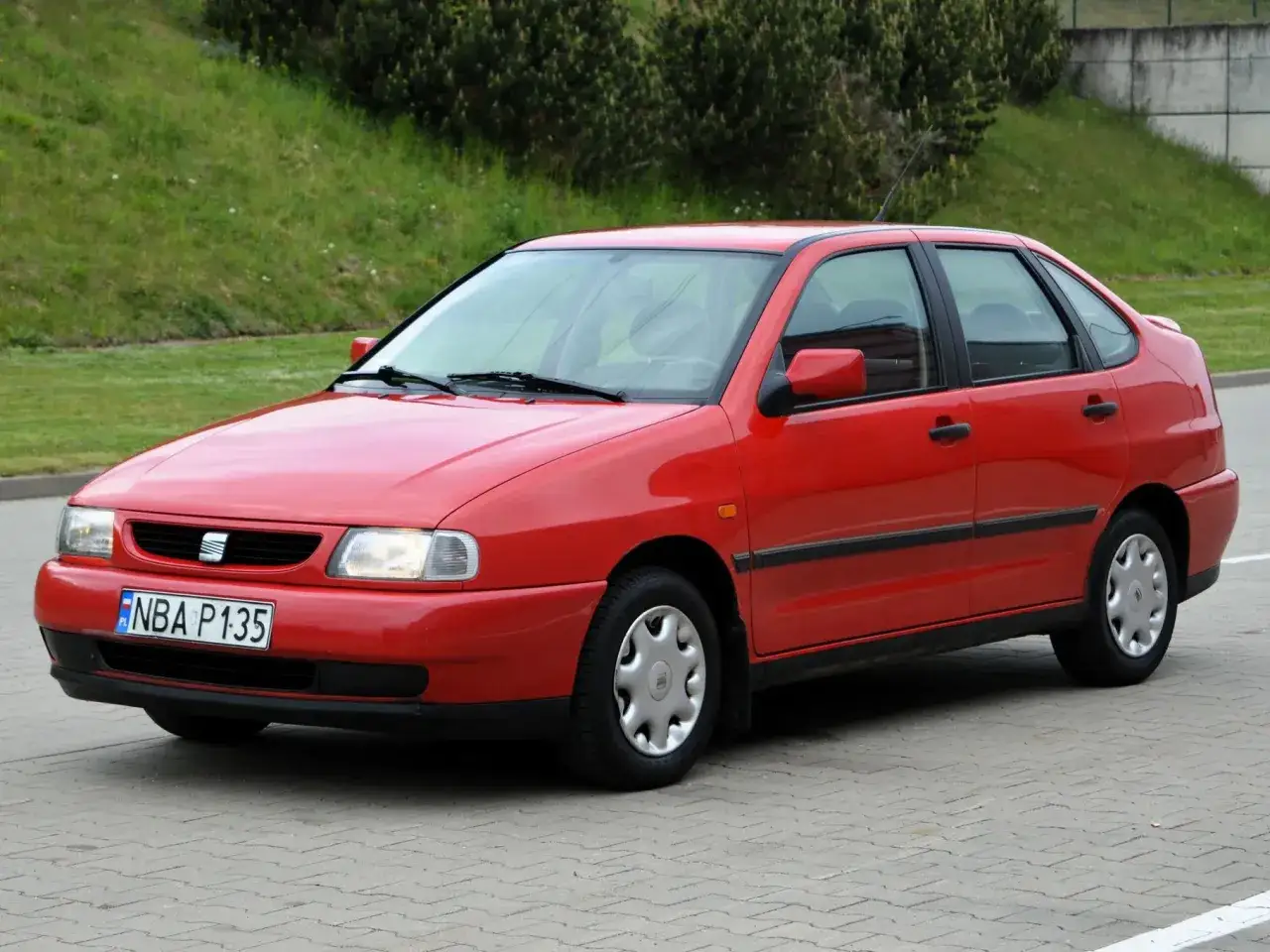 Czerwony Seat Cordoba z lat 90. na parkingu.