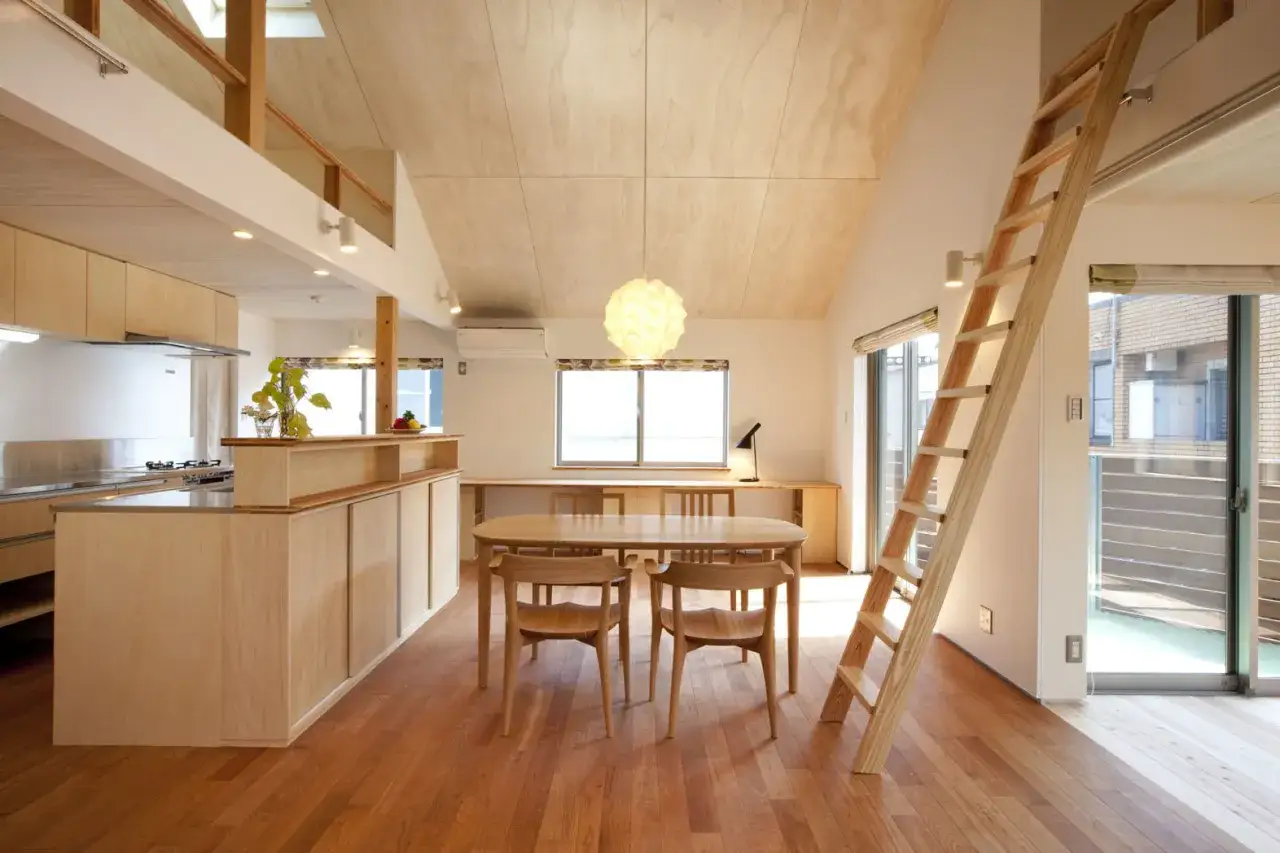 Interno moderno con cucina, sala da pranzo e scala in **legno massiccio**. Pavimenti e arredi in tonalit&agrave; chiare creano un'atmosfera luminosa e accogliente.