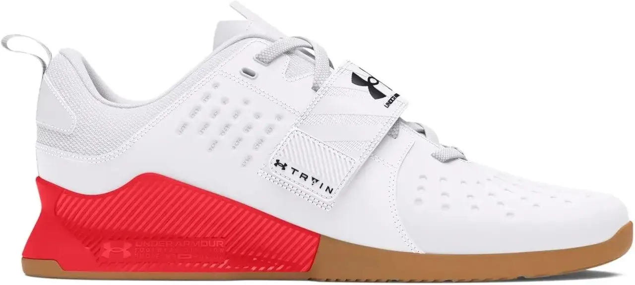 Zapatilla blanca de entrenamiento con suela de goma y detalles rojos. El sistema de cierre con velcro y cordones asegura un ajuste firme, ideal para el **heel lock lacing**.
