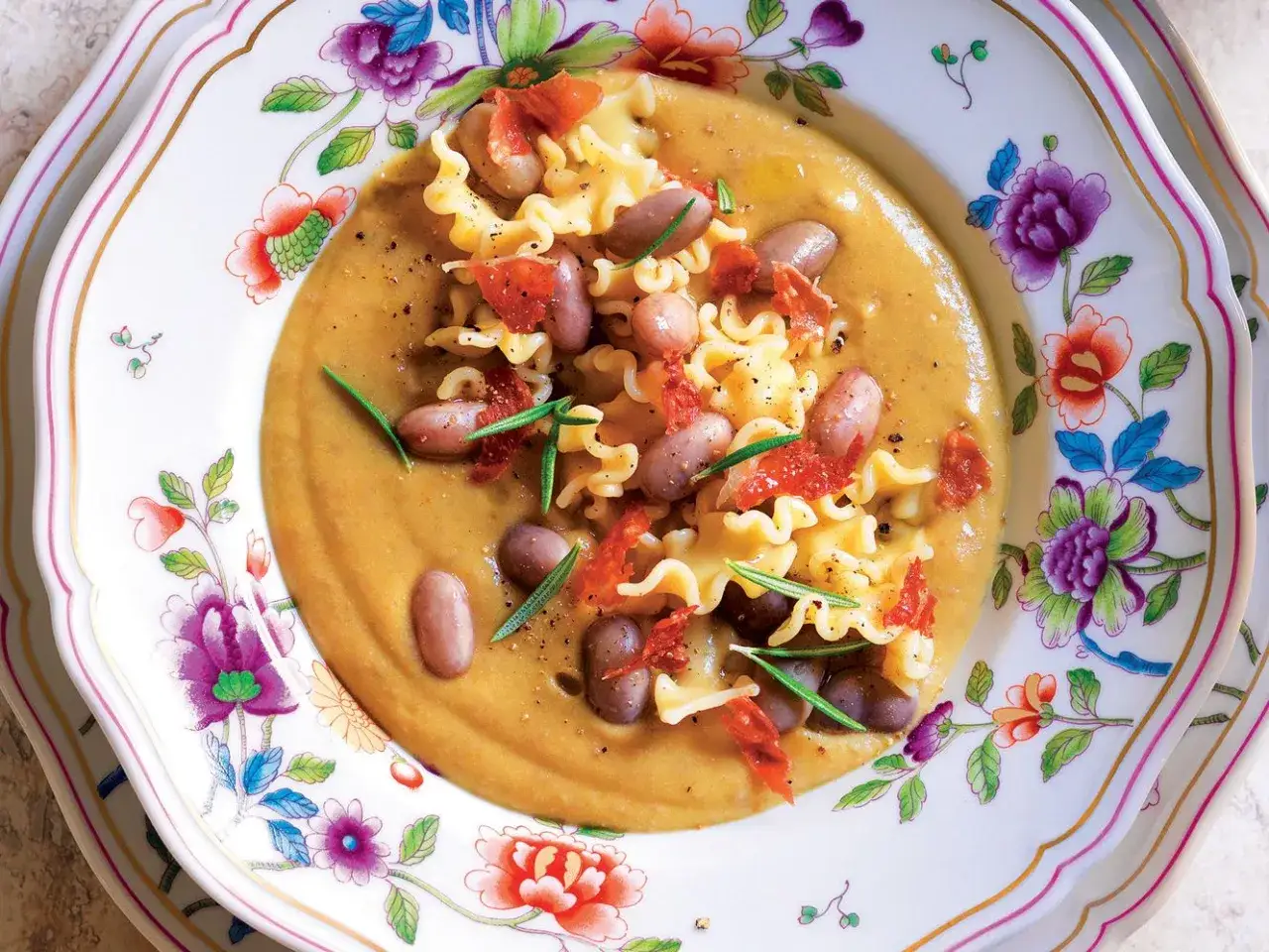Piatto di pasta con crema di legumi, fagioli borlotti, pomodori secchi e rosmarino. Un'idea gustosa per le tue ricette con legumi.