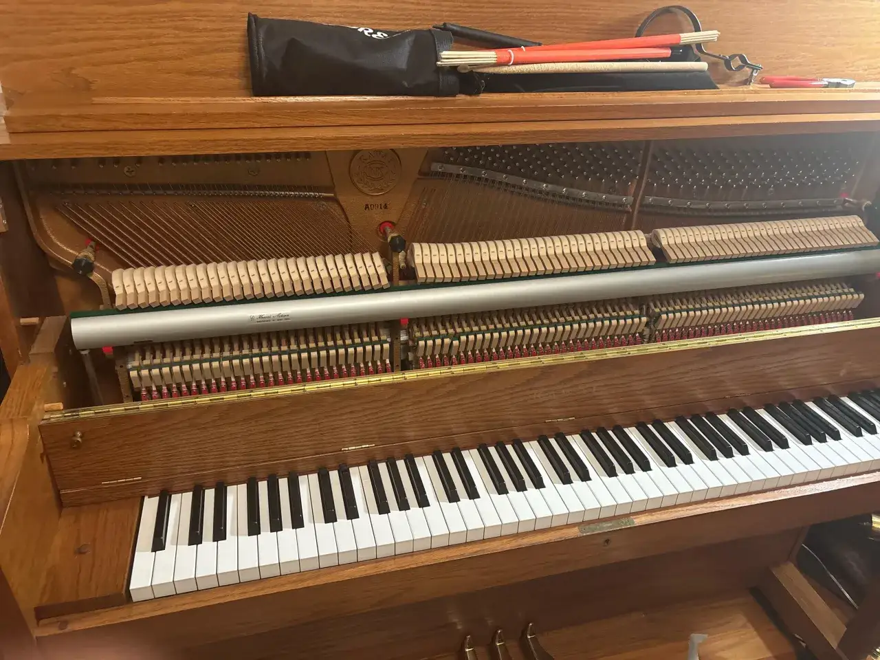 Wnętrze pianina z widocznymi strunami i mechanizmem młoteczkowym. Czy pianino jest instrumentem strunowym? Tak, jego dźwięk powstaje dzięki drganiom strun.