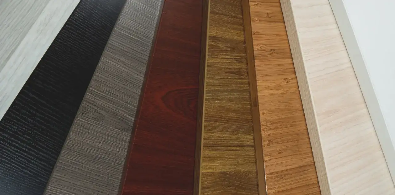 A selection of desk wood types, showcasing various grains and colors from light blonde to dark espresso, including bamboo and rich cherry.