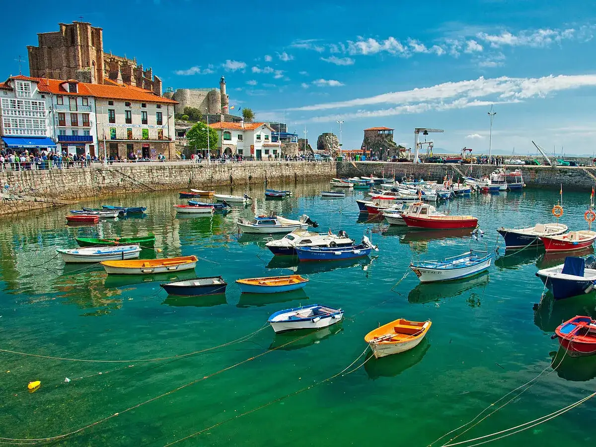 Puerto pesquero con barcas de colores. Un lugar ideal que ver en el norte de España, con edificios históricos y aguas cristalinas.