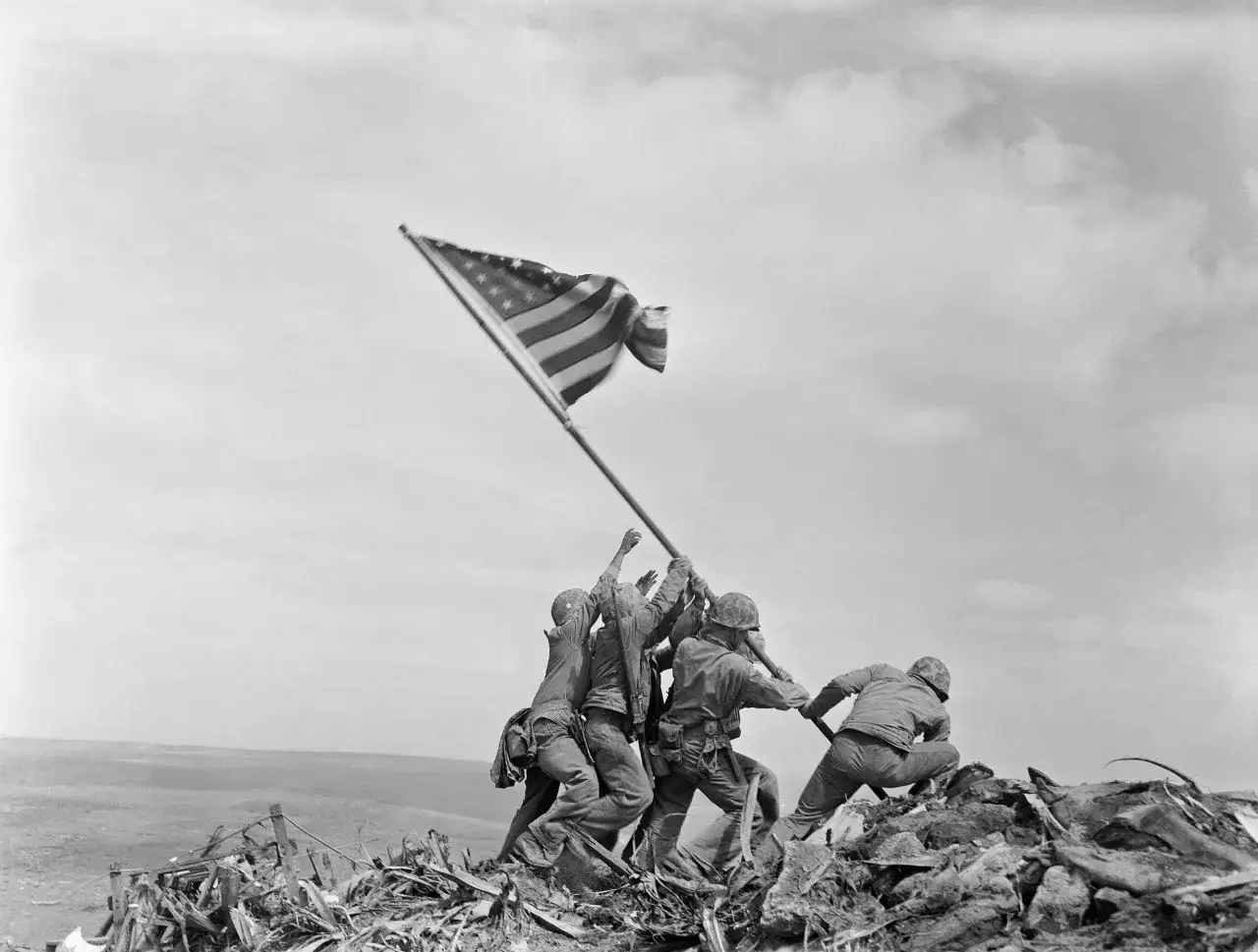 Soldati issano la bandiera americana sul monte Suribachi, un'iconica immagine di Robert Capa.