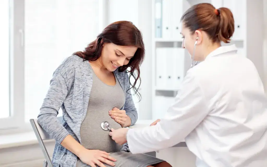 Kobieta w ciąży rozmawiająca z pracownikiem socjalnym w biurze MOPS