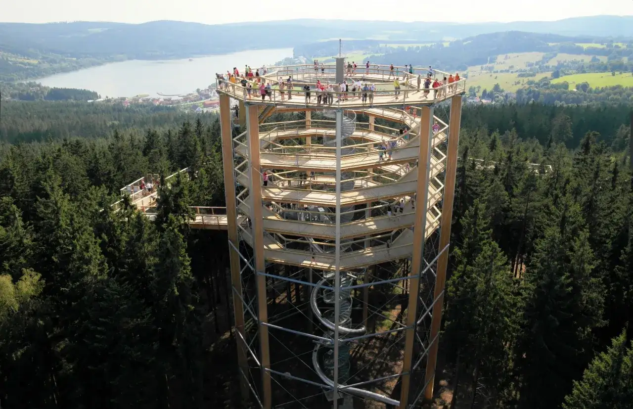 Der Baumwipfelpfad Lipno bietet einen atemberaubenden Blick &uuml;ber den Wald und den See. Besucher genie&szlig;en die Aussicht von der spiralf&ouml;rmigen Holzkonstruktion.