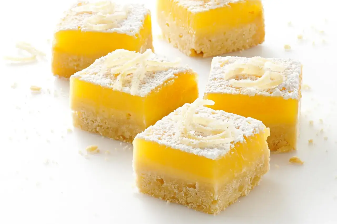 Citronrutor med en smulig botten, pudrade med florsocker och garnerade med citronskal. Perfekt för överblivna äggulor recept.