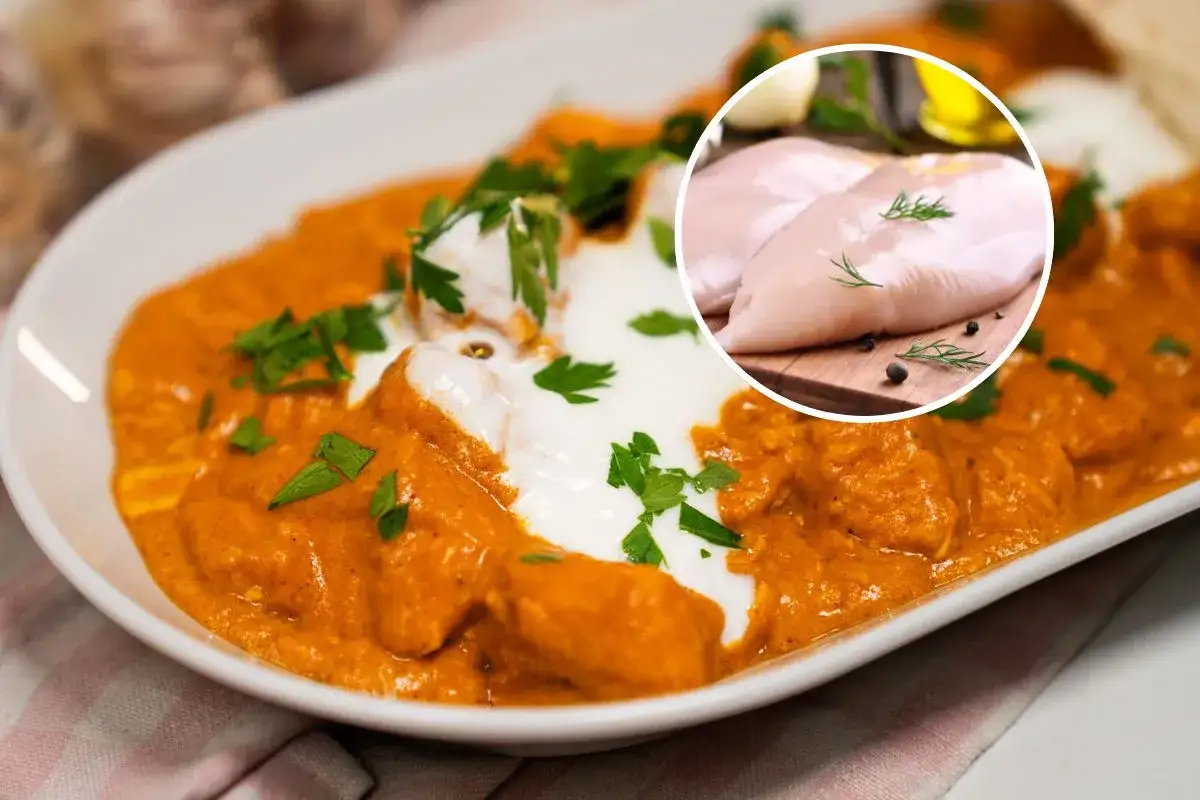 Aksamitny sos pomidorowy z kawałkami kurczaka, polany śmietaną i posypany natką pietruszki. W rogu surowe piersi kurczaka, składniki do butter chicken.