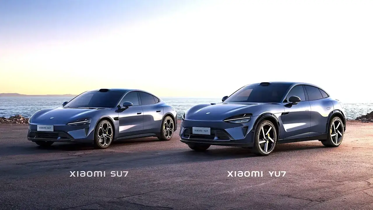 Due **xiaomi auto** blu, SU7 e YU7, si stagliano su uno sfondo marino al tramonto.