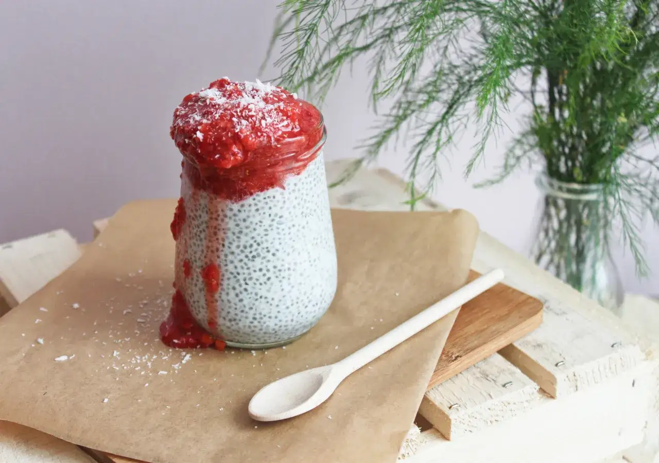 Pudding chia z musem truskawkowym i wiórkami kokosowymi. Zastanawiasz się, dlaczego pudding chia nie gęstnieje? Może zabrakło czasu lub płynu?