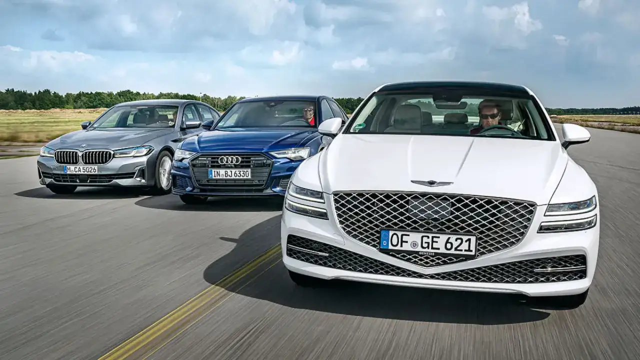 El Genesis Espa&ntilde;a compite en carretera con un BMW gris y un Audi azul.