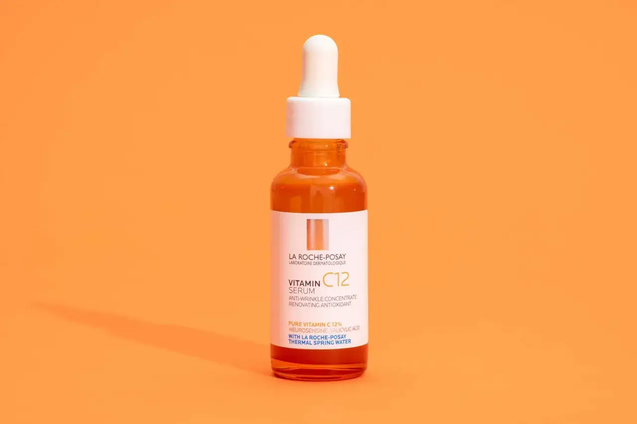 Orangefarbene Flasche mit Vitamin C Serum. Enthält Ascorbyl Tetraisopalmitat für jugendliche Haut.