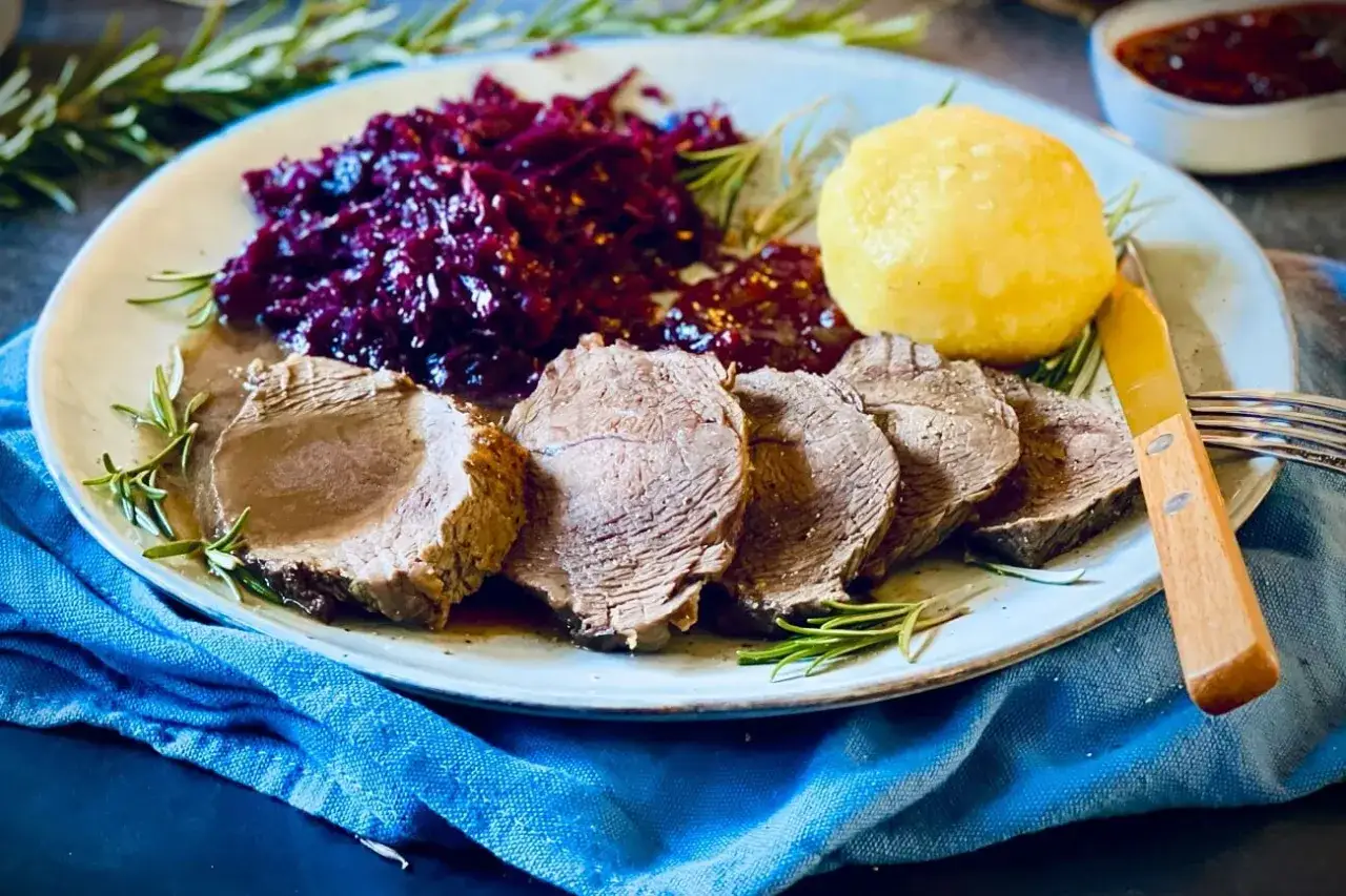 Saftiger Rinderbraten, serviert mit Rotkohl und Kl&ouml;&szlig;en &ndash; ein klassisches rinderbraten rezept, das Appetit macht.
